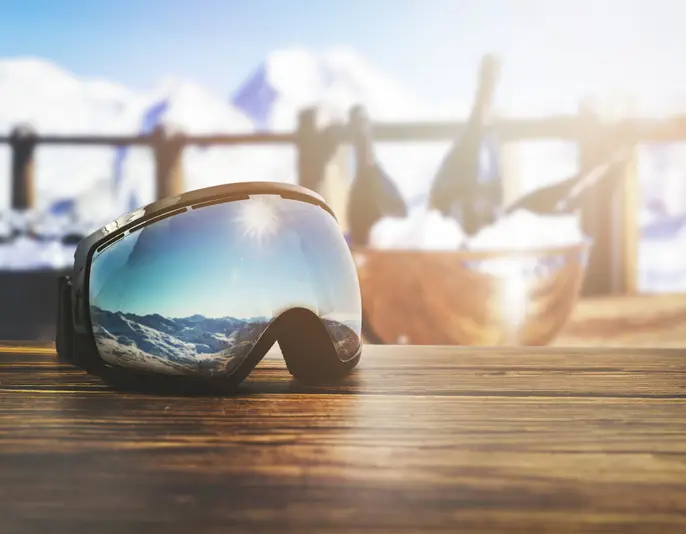 apres ski - goggles with mountains reflection on the restaurant table at ski resort